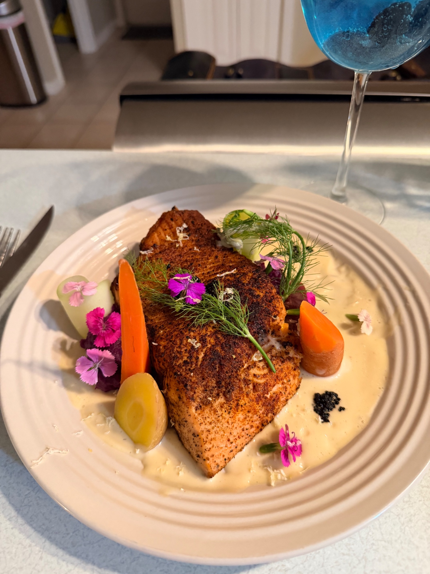 Private dinner salmon course set beside a blue wine glass