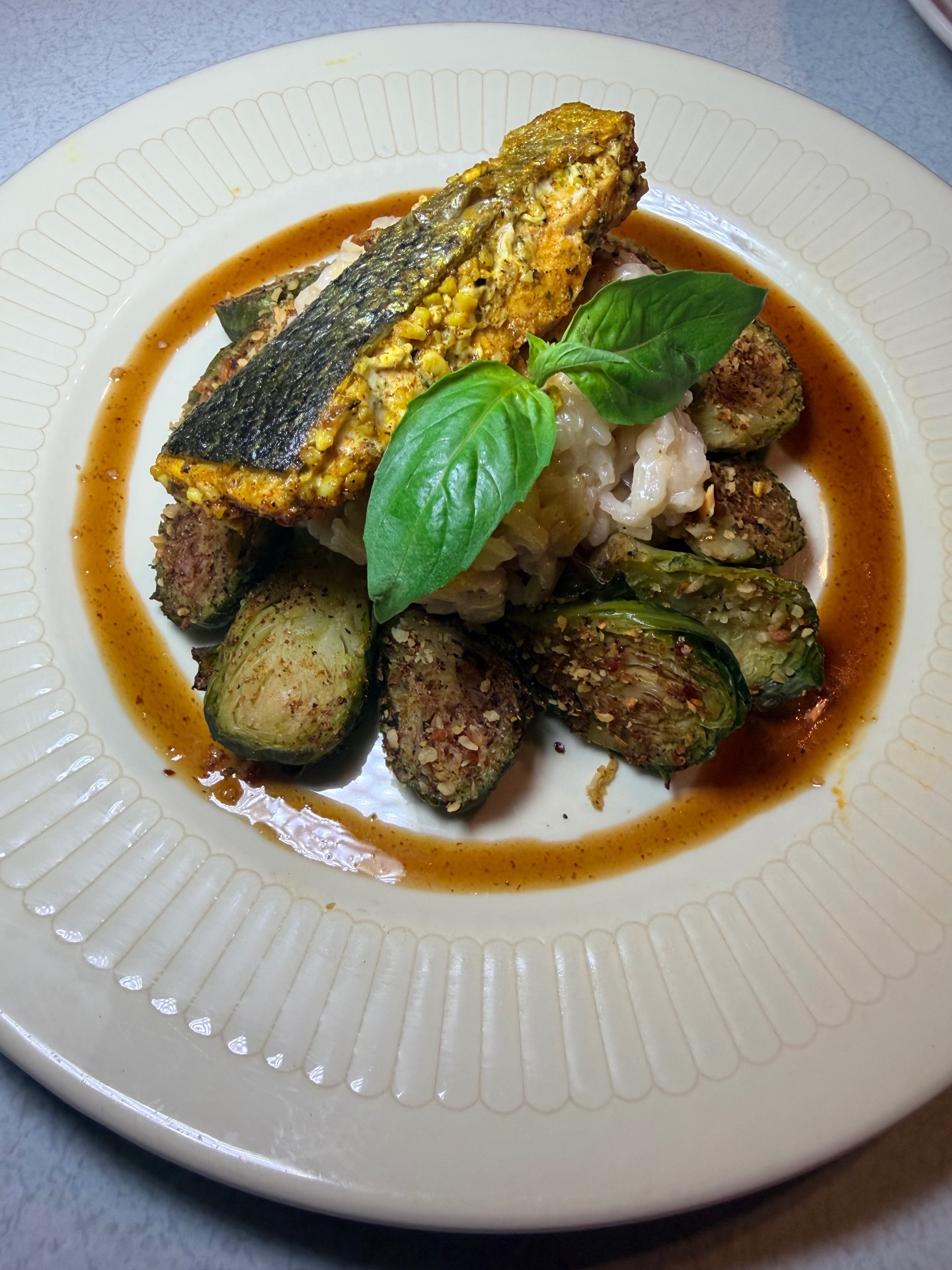 Crispy pan-seared bass with roasted Brussels sprouts, basil, and amber jus